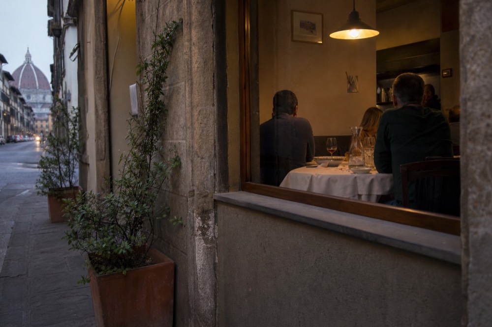 Casually dressed diners at a set table in a small Italian restaurant, no text, no logos, no people