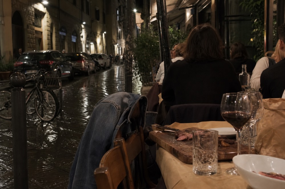 Florentine steak dinner setting with wine glasses and a warm dining room, no text, no logos, no people