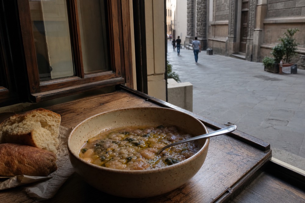 Bowl of ribollita Tuscan bread soup with olive oil on a rustic table, no text, no logos, no people