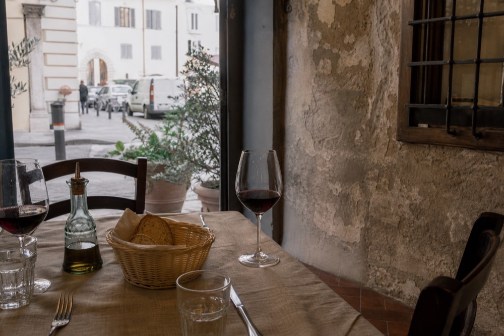 A trattoria table set with bread, olive oil and wine glasses in Florence, no text, no logos, no people