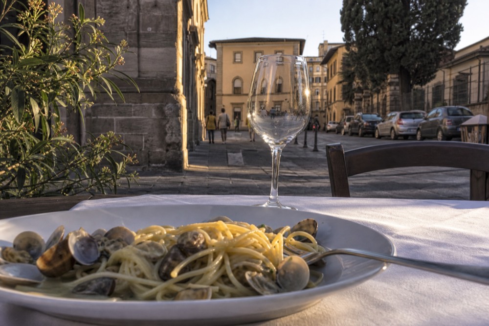 A plate of fresh pasta with clams on a trattoria table in Florence, no text, no logos, no people
