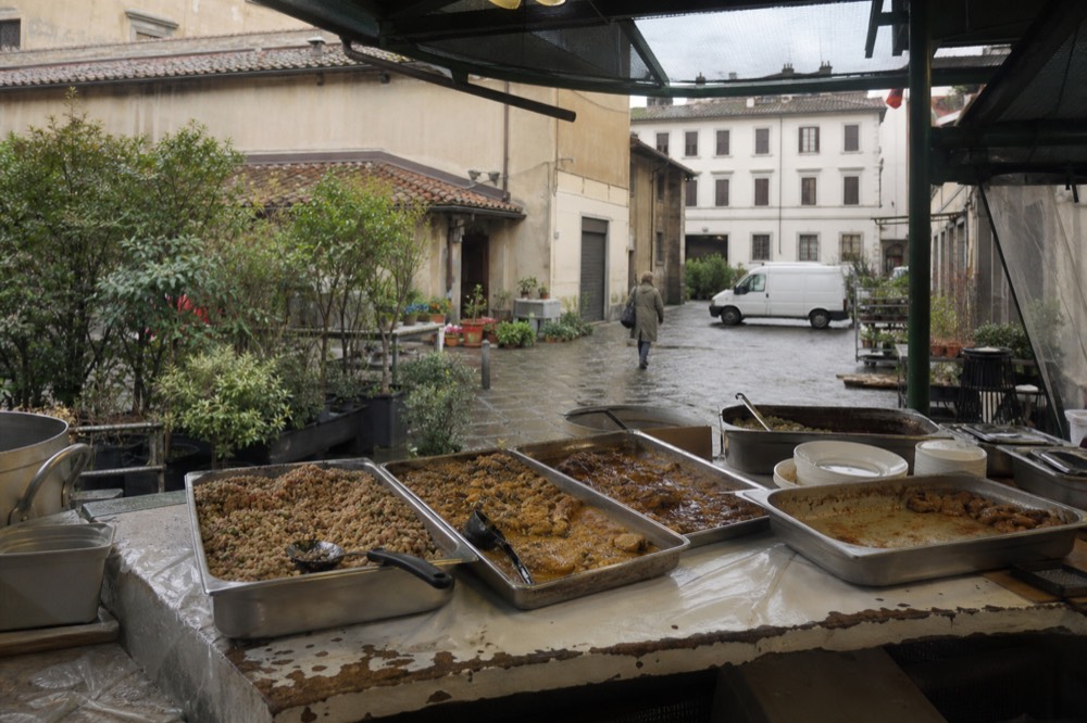 A Florence market stall with trays of cooked dishes and a counter, no text, no logos, no people