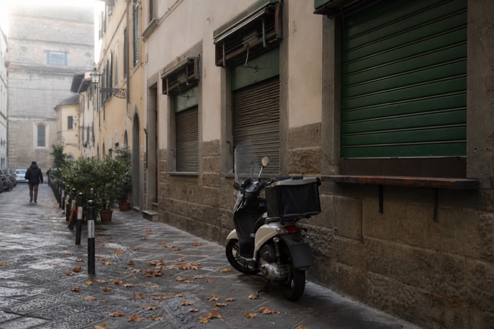 A quiet Florence side street with a small neighbourhood eatery, no text, no logos, no people