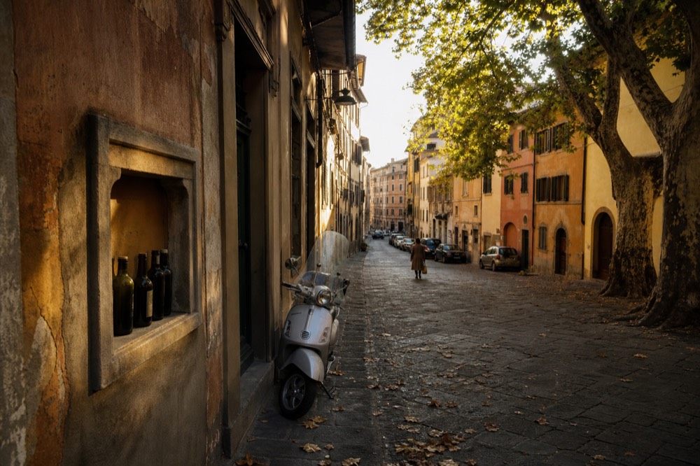 A golden Florentine street corner in late afternoon light with shuttered wine windows in an old wall, no text, no logos, no people
