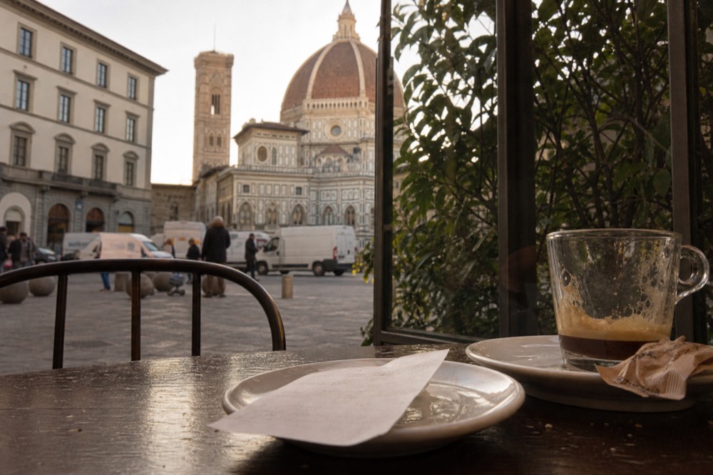 A restaurant bill on a saucer beside an espresso cup, no text, no logos, no people