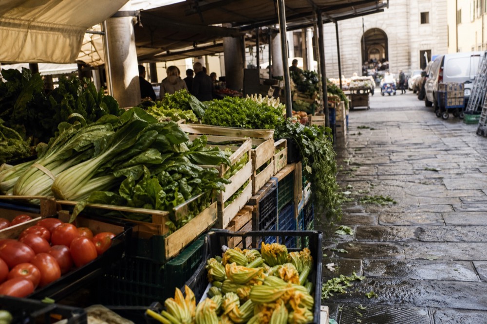 A busy Florence food market stall with fresh vegetables and produce, no text, no logos, no people