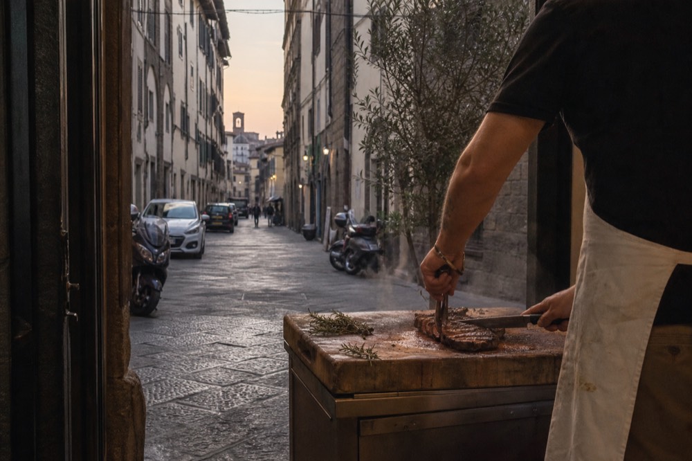 A chef carving a grilled steak at a trattoria counter, no text, no logos, no people