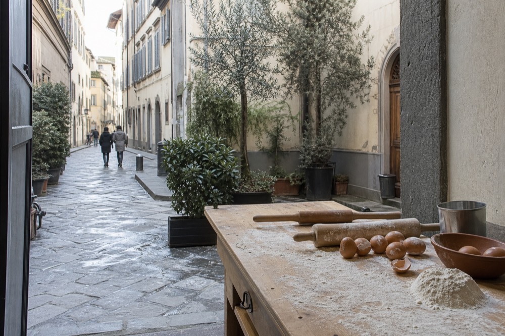 Rolling pins, flour and eggs arranged on a rustic kitchen table ready for a cooking lesson, no text, no logos, no people
