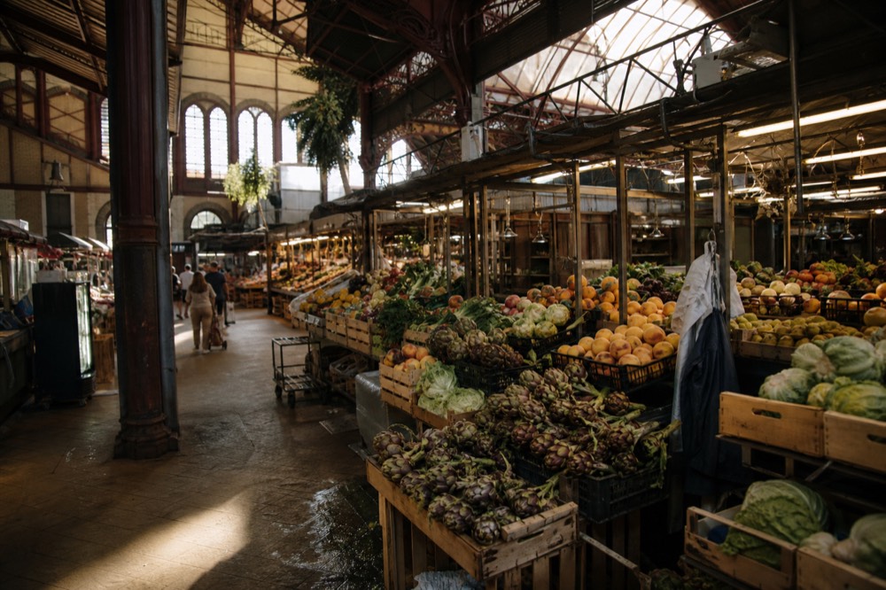 A Florence market hall with produce stalls in morning light, no text, no logos, no people