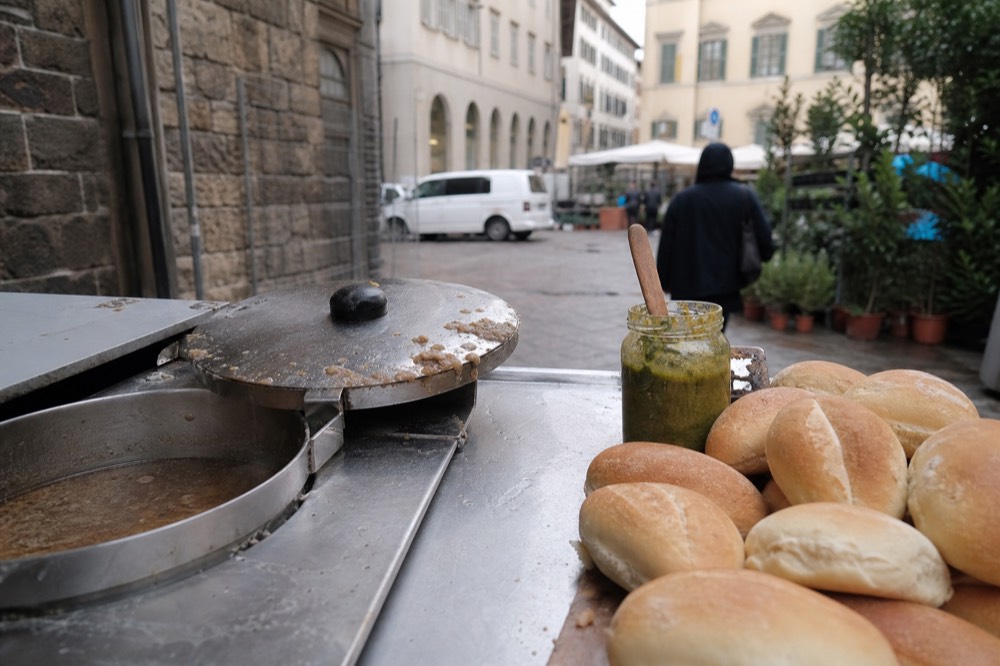 A lampredotto cart pot with bread rolls beside it, no text, no logos, no people