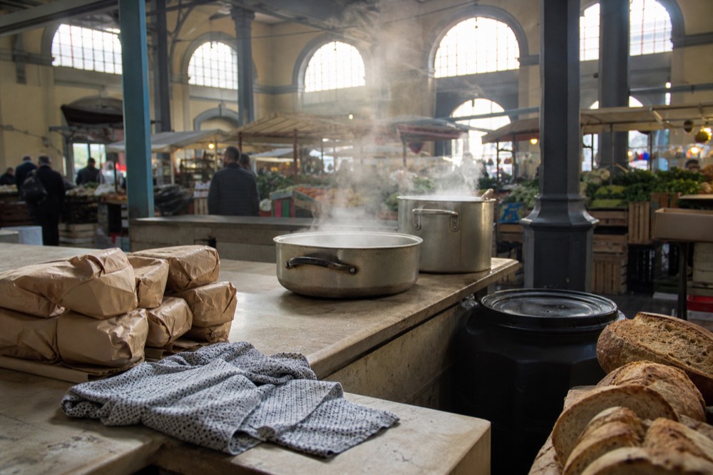 A market stall counter with steaming pots and bread, no text, no logos, no people