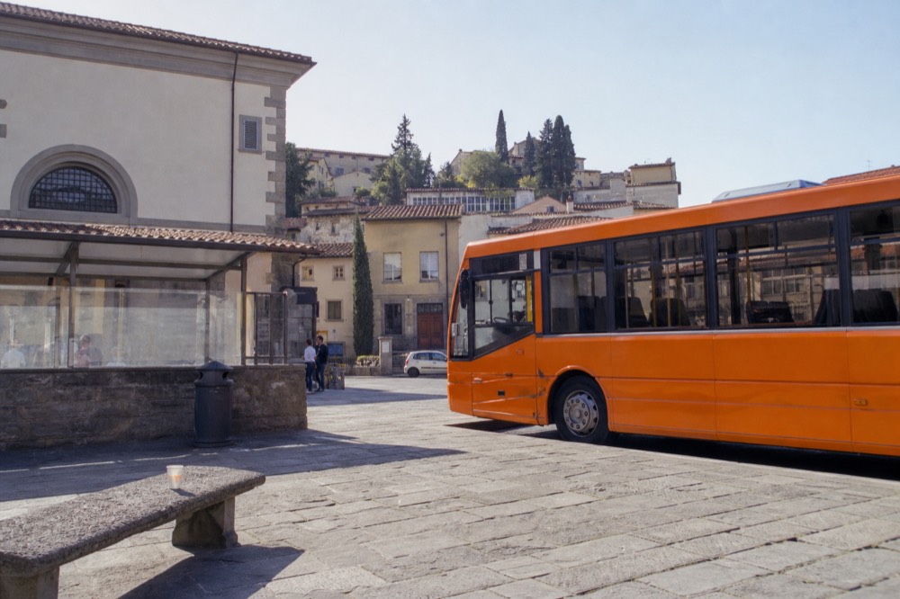 A country bus parked on a square in a small Chianti town, no text, no logos, no people