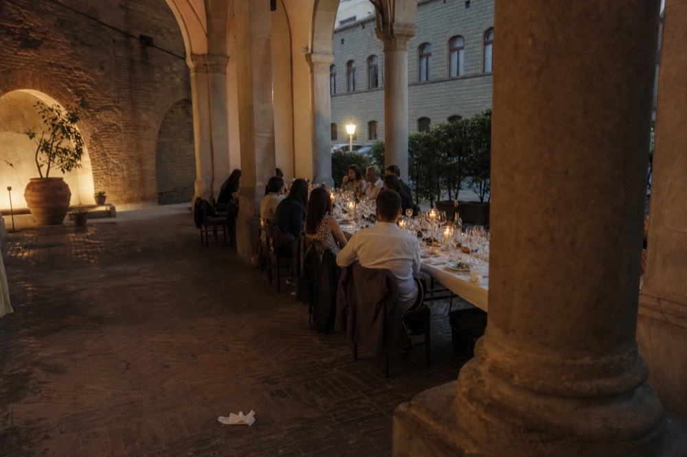 Long table set for a group dinner with wine glasses and bread, no text, no logos, no people