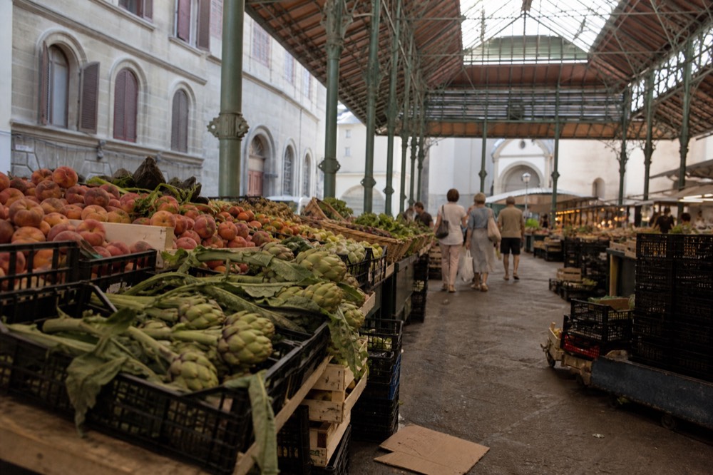Ground floor of Mercato Centrale with fresh produce stalls and shoppers, no text, no logos, no people