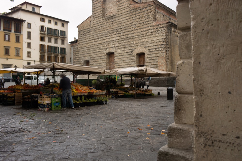 Santo Spirito market stalls with fresh produce and a church in background, no text, no logos, no people
