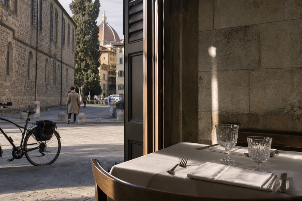 Neatly set table with linen napkin and crystal glassware in soft restaurant light, no text, no logos, no people