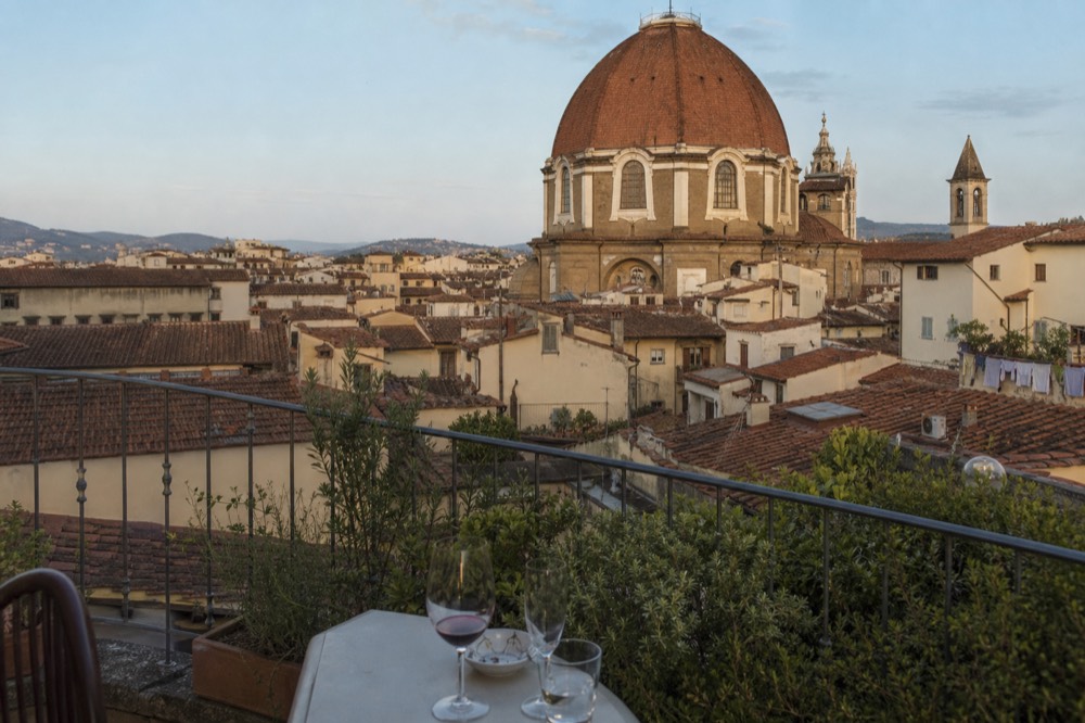 Rooftop terrace overlooking Florence cathedral and terracotta rooftops, no text, no logos, no people