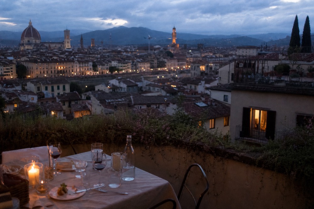 Dinner table on a terrace above Florence at dusk, no text, no logos, no people