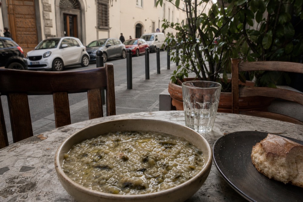 A bowl of thick Tuscan bread soup with olive oil drizzled on top, no text, no logos, no people
