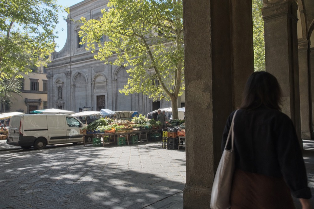 Santo Spirito square in Florence at lunchtime with market stalls, no text, no logos, no people