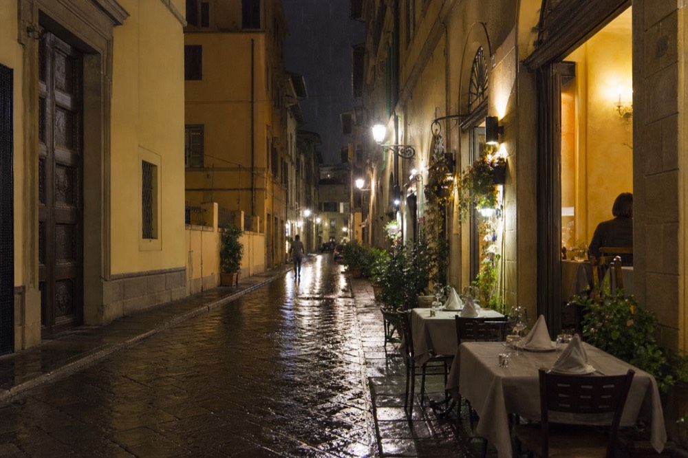 Evening in a Florence side street with lit restaurant windows, no text, no logos, no people