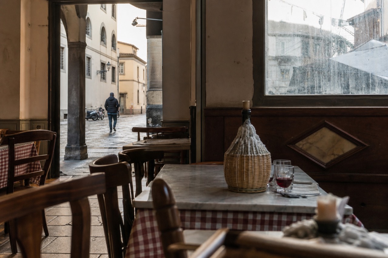A small Florentine trattoria interior with marble table and Chianti flask, no text, no logos, no people